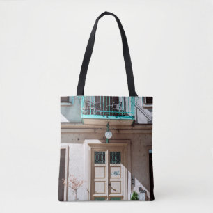 Brown wooden door on white concrete building tote bag
