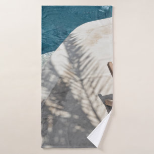 Brown wooden lounger near body of water bath towel