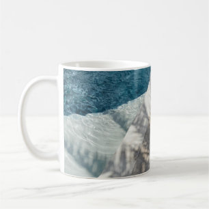 Brown wooden lounger near body of water coffee mug