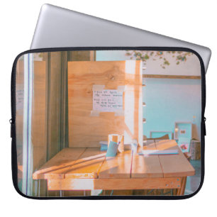 BROWN WOODEN TABLE WITH WHITE PRINTER PAPER LAPTOP SLEEVE