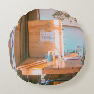 BROWN WOODEN TABLE WITH WHITE PRINTER PAPER ROUND PILLOW