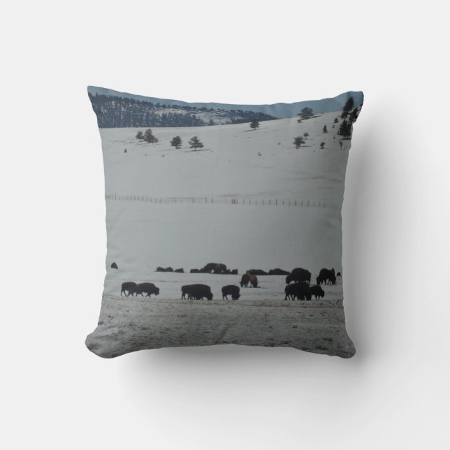 Buffalo grazing on snow covered mountain throw pillow (Front)