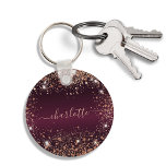 Burgundy rose gold glitter dust name script keychain<br><div class="desc">A burgundy faux metallic looking background colour. Decorated with rose gold faux glitter dust. Personalize and add a name. The name is written with a modern hand lettered style script with swashes. To keep the swashes only delete the sample name, leave the spaces or emoji's in front and after the...</div>