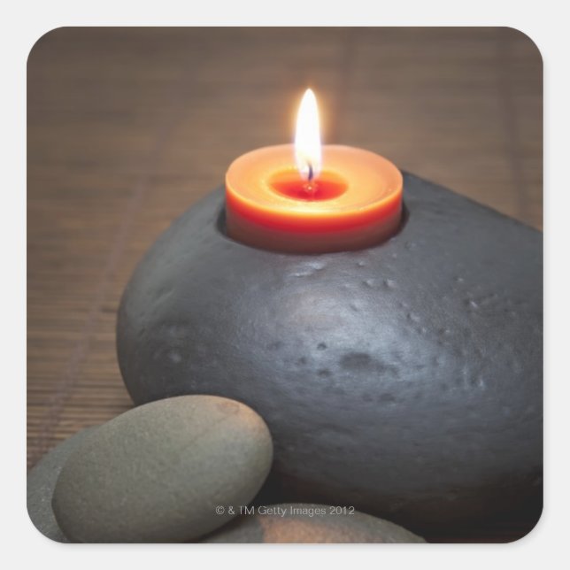 Burning candle flame with rocks in tranquil square sticker (Front)