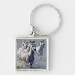 Camargue horses running on marshland to cross keychain