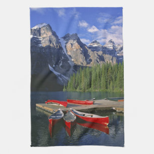 Canada, Alberta, Moraine Lake. Red canoes await Kitchen Towel
