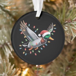 Canard de Noël volant avec des lumières de chasse