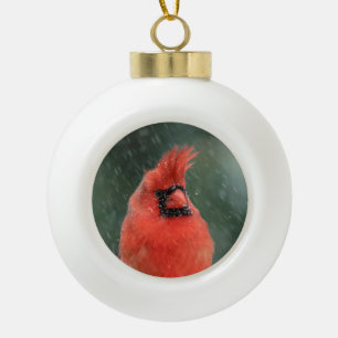 Cardinal in a pine tree during a snow storm ceramic ball christmas ornament