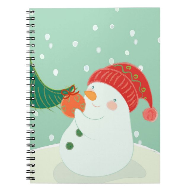 Carnet Un bonhomme de neige accrochant un ornement sur un (Devant)