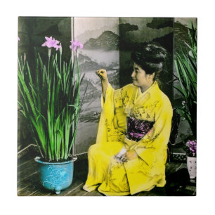 Carreau Geisha dans le kimono jaune arrangeant des fleurs