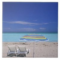 Parapluie et deux chaises longues sur la plage,