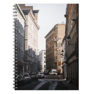 CARS PARKED ON SIDE OF THE ROAD IN BETWEEN BUILDIN NOTEBOOK