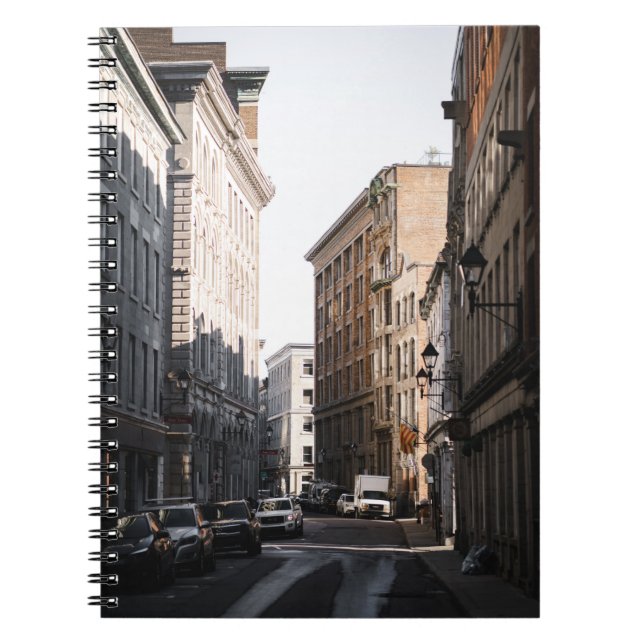 CARS PARKED ON SIDE OF THE ROAD IN BETWEEN BUILDIN NOTEBOOK (Front)