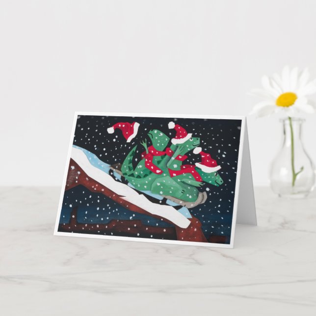 Carte A whimsical holiday card with sledding dinosaurs (Petite plante)