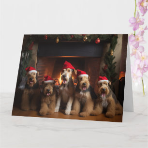 Carte Airedale près de la cheminée Noël