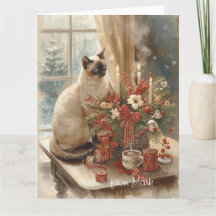 Chat siamois arrangeant des fleurs en hiver Noël