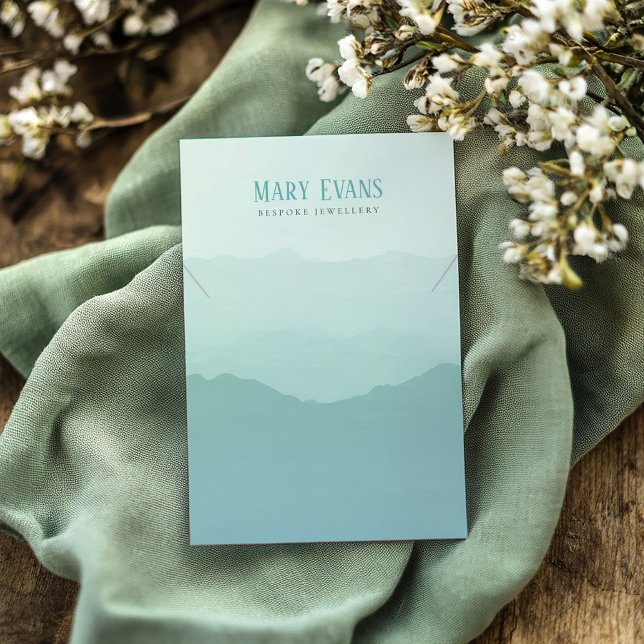 Carte d'affichage du collier vert et bleu de monta (Green necklace display card featuring a delicate watercolor soft green mountains)