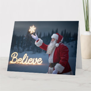 Carte Père Noël tenant un flocon de neige lumineux