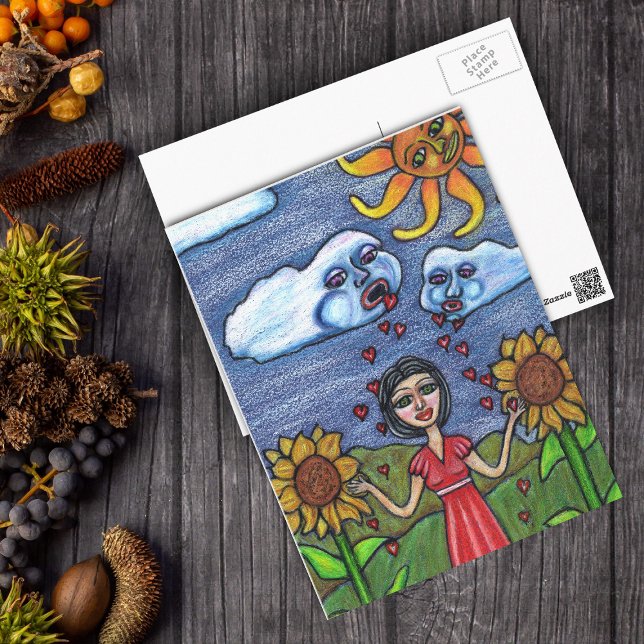Carte Postale L'amour te fera grandir (Clouds raining red hearts down on lady in sunflowers with orange sun looking on postcard.)