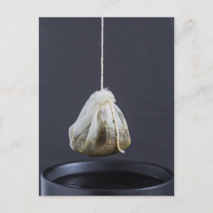 Carte Postale Le sac de thé est suspendu dans une tasse