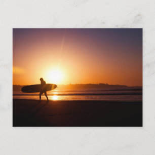Carte Postale Surfer en planche de surf sur la plage au coucher