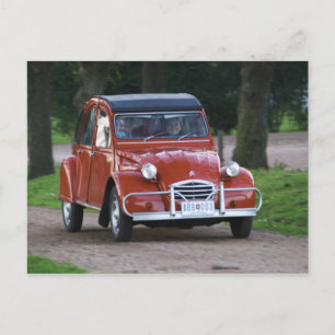 Carte Postale Une vieille voiture rouge Citroen 2CV avec une fem