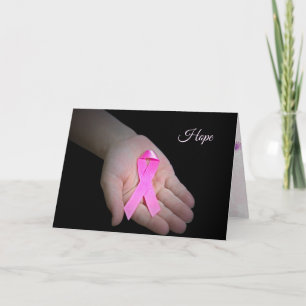 Carte ruban rose du cancer du sein dans la main de la fi