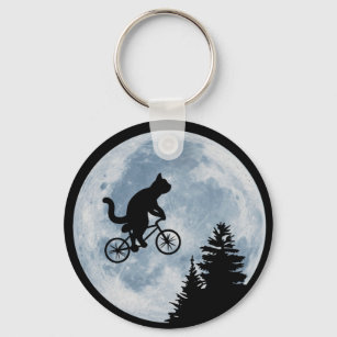 Cat is riding bicycle on the moon background. keychain