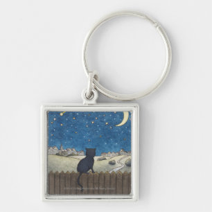 Cat on a fence looking at night sky above city keychain