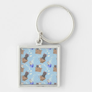 Cats in box and milk drops on blue keychain