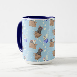 Cats in box and milk drops on blue mug