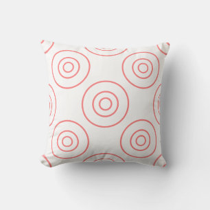 Cercles roses sur un coussin blanc
