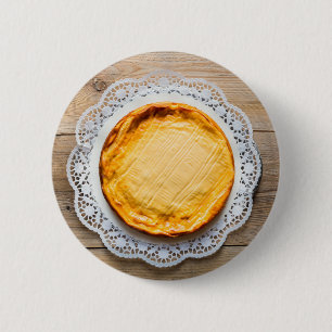 Cheesecake on rustic wood cake top. 2 inch round button