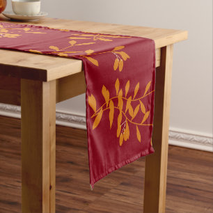 Chemin De Table Court Feuilles de branches de silhouette orange sur roug