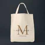 Chic Gold Monogram Script Names Wedding Date Tote Bag<br><div class="desc">Chic, modern gold monogrammed tote bag with your names and year established in black elegant hand lettered script calligraphy with a gold monogram. Simply add your names, monogram and year established beneath. Stylish design and perfect gift for the wedding guests of the newlywed couple. If you need any help or...</div>