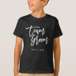 Chic Trendy Brush White Script Team Groom T-Shirt<br><div class="desc">T-shirt featuring the words "Team Groom" in chic trendy brush white script that's perfect for the ring bearer. For other matching items see here https://www.zazzle.com/collections/119250194970828530?rf=238364477188679314 Personalize it by replacing the placeholder text. For more options such as to change the font and it's size, colour or the spacing between letters click...</div>