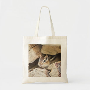 Chipmunk in a wood pile tote bag