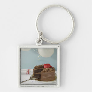 Chocolate cake with missing slice on table, keychain
