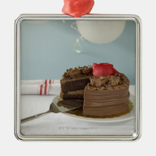 Chocolate cake with missing slice on table, metal ornament