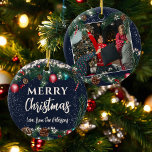Christmas lights pine branches snow blue photo ceramic ornament<br><div class="desc">Celebrate your holiday memories with this charming round Christmas tree ornament. Featuring a festive green pine garland with sparkling lights, pine cones, and red and blue baubles, this ornament allows for customization with your family's name on the front and a cherished photo on the back. Perfect for adding a personalized...</div>