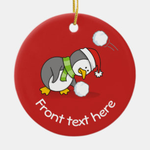 Christmas penguin getting a snow ball ceramic ornament