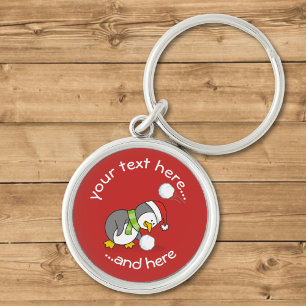 Christmas penguin getting a snow ball keychain