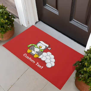 Christmas penguin sitting with snow balls doormat