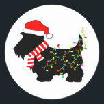 Christmas Scottie Dog With Lights Classic Round Sticker<br><div class="desc">Scottish Terrier dog lovers will enjoy this festive,  black Scottie Dog wearing a Santa hat,  red and white striped scarf and colourful string lights!  Get into the Christmas spirit with this funny design on customizable gifts!</div>