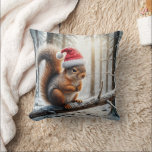 Christmas Squirrel On Snowy Tree Branch Throw Pillow<br><div class="desc">A squirrel wearing a Santa hat is perched on a snow-covered branch in a wintry forest,  with sunlight filtering through the trees</div>