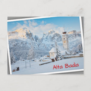 Church covered in snow with mountain background postcard