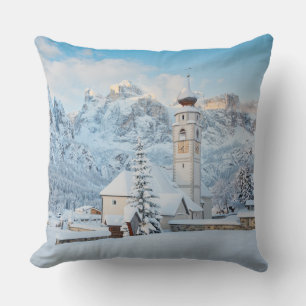 Church covered in snow with mountain background throw pillow