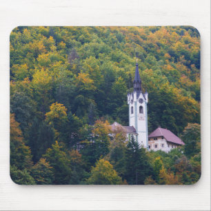 Church in a fall forest in Slovenia Mouse Pad