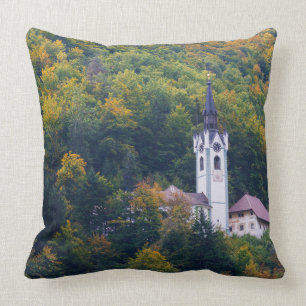 Church in a fall forest in Slovenia Throw Pillow