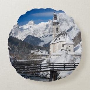 Church in the snow with Alps mountains Round Pillow